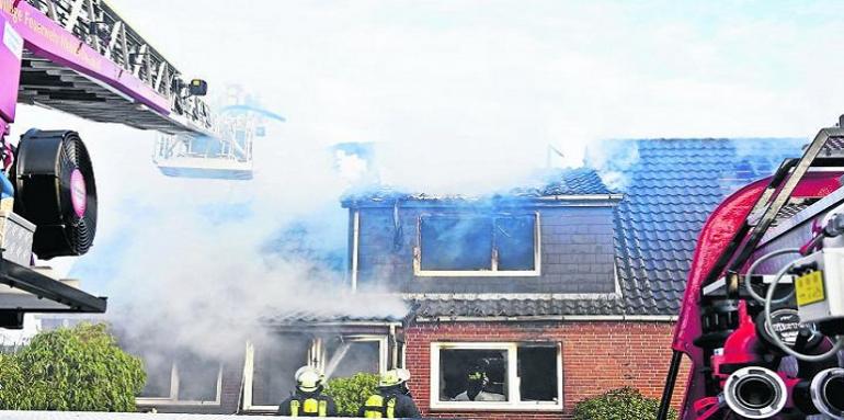 Casa quemándose y carro de bomberos  
