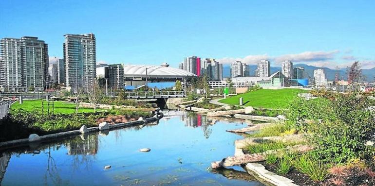 Ciudad, edificios al rededor de lago y zona verde