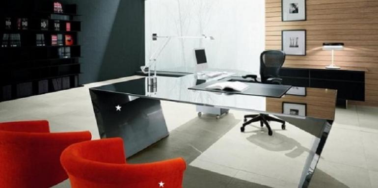 Escritorio de vidrio silla negra y sofás rojos
