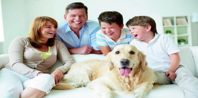 Familia feliz con perro sentada en sofa