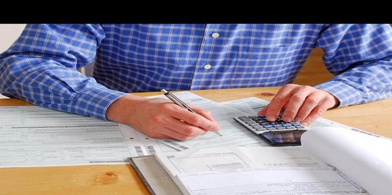 Hombre haciendo cuentas con calculadora y lápiz en la mano