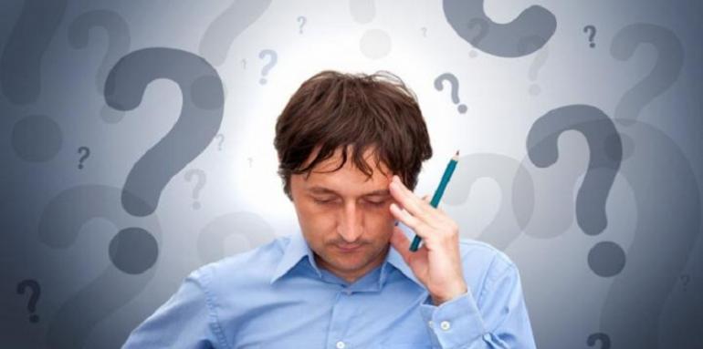 Hombre preocupado entre signos de interrogación