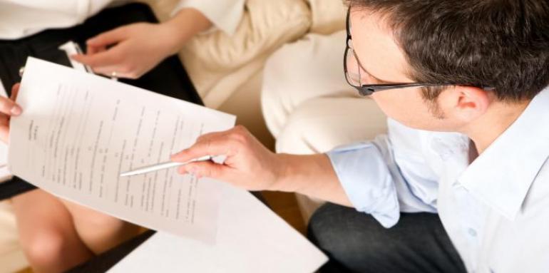hombre señalando con esfero papel en reunión
