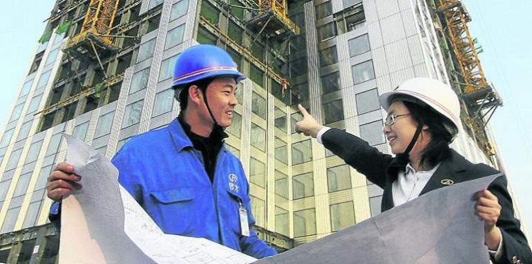 Pareja china con casco señalando edificio