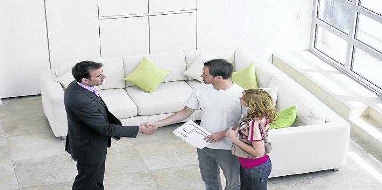 Pareja conociendo vivienda enseñada por hombre 