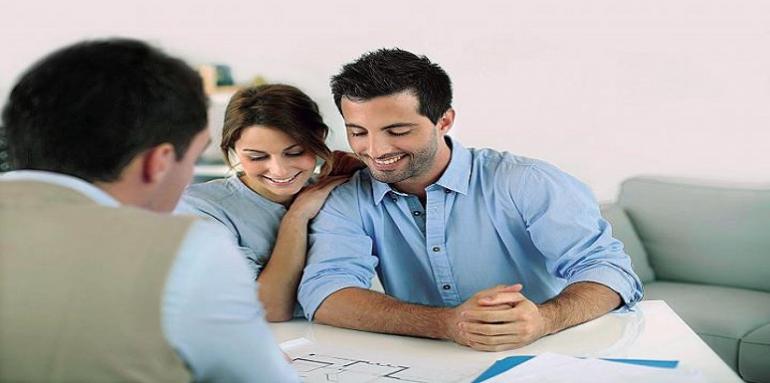 Pareja feliz revisando planos con vendedor