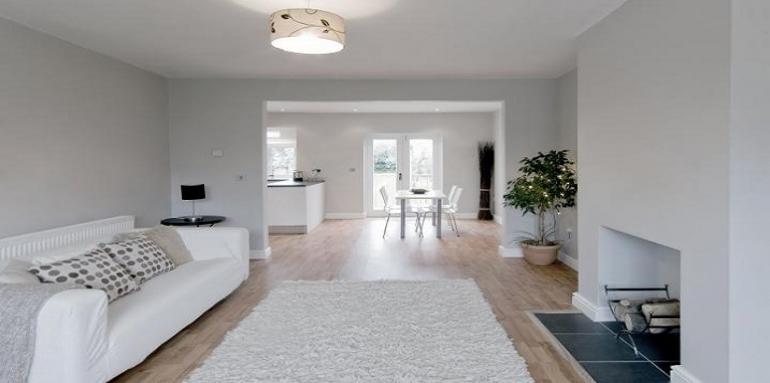 Sala con chimenea paredes tapete y sofá blanco