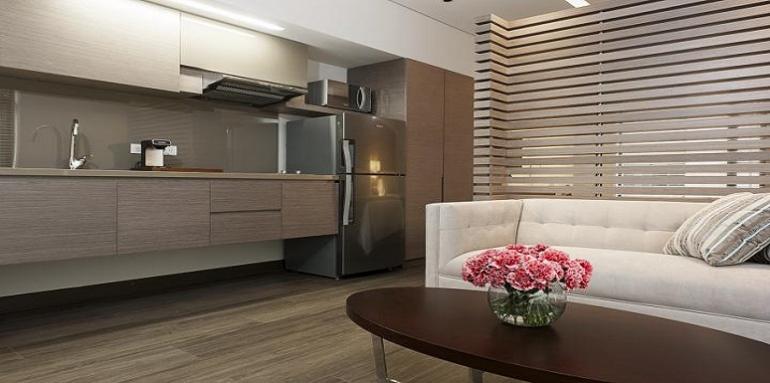 Sala con sofá blanco en frente de pequeña cocina