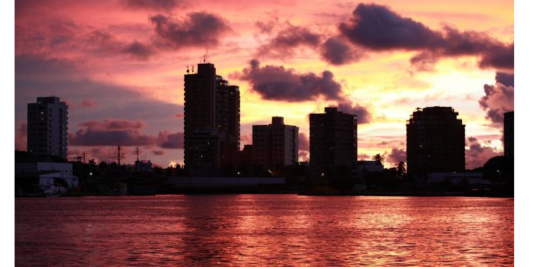 Atardecer morado con edificios y mar