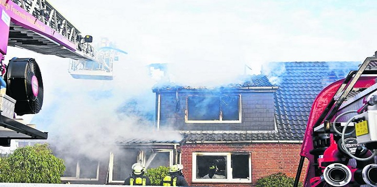 Casa quemándose y carro de bomberos  