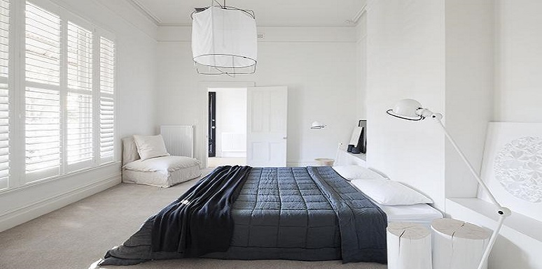 Habitación paredes blancas cama con tendido negro