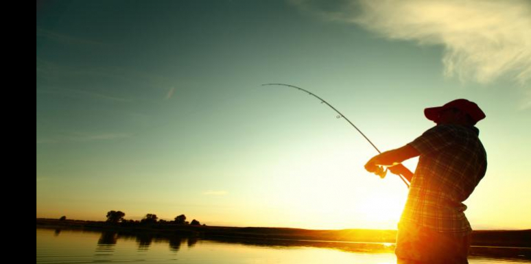 Hombre con caña de pescar en atardecer