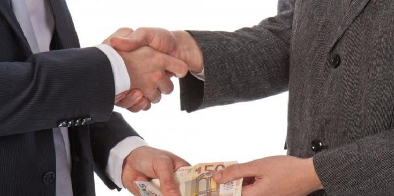 Hombres dándose la mano y dinero