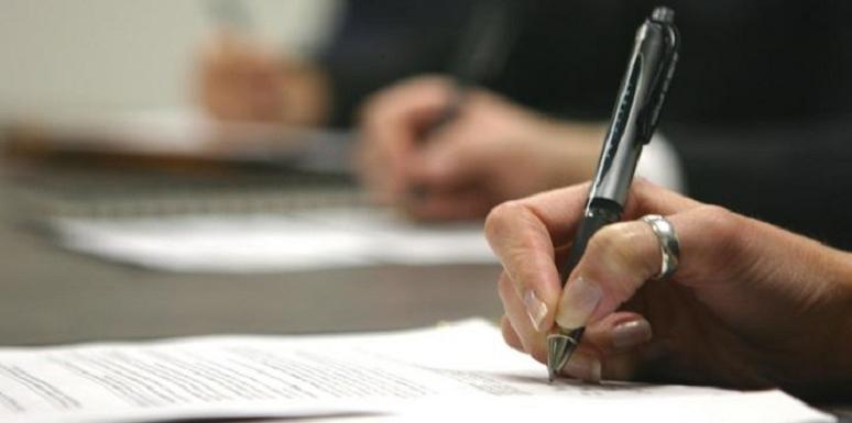 Mano de mujer firmando papeles
