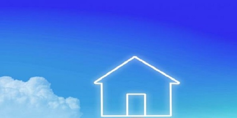 Mano sosteniendo monedas con casa pintada en el cielo