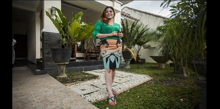 Mujer posando frente a casa