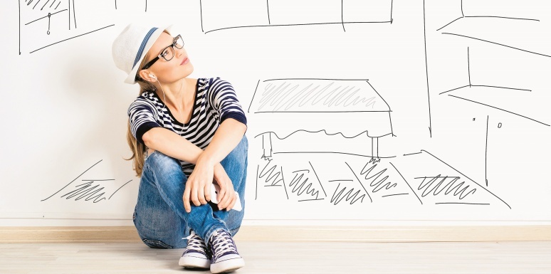 Mujer sentada junto a una pared con dibujos