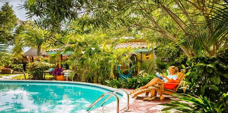 Mujer leyendo al borde de una piscina