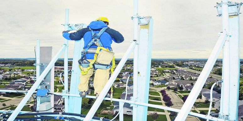 Obrero subido en andamio con arnés y caso