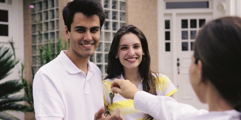 Pareja recibiendo llaves de un inmueble