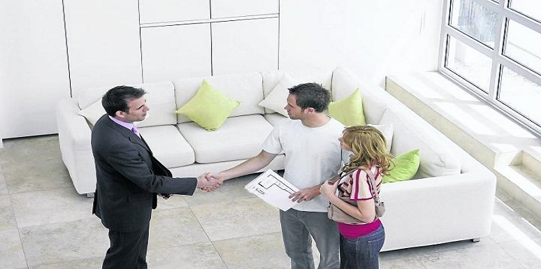 Pareja conociendo vivienda enseñada por hombre 