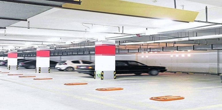 Parqueadero edificio con carro negro y carro blanco