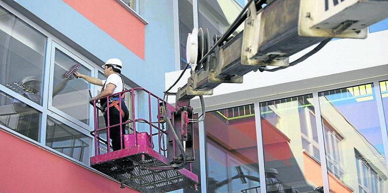 Persona limpiando ventana de edificio 