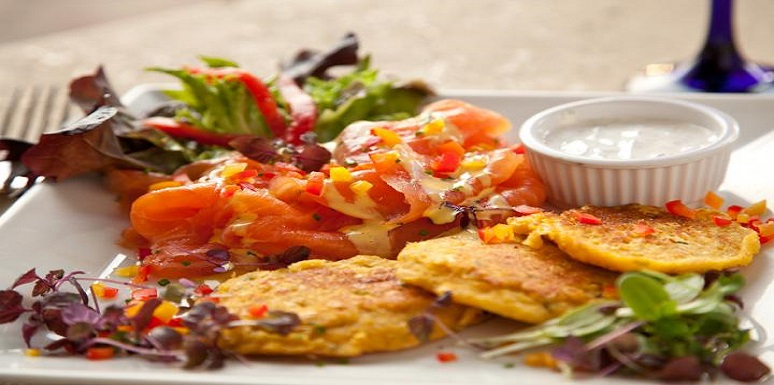Plato de comida con mariscos, patacón y salsa