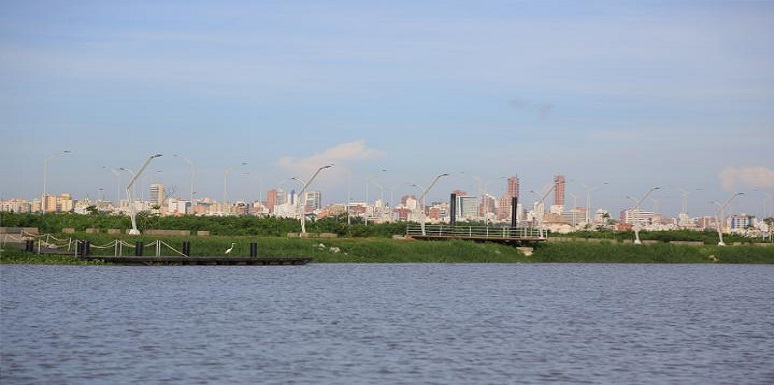 Rio Magdalena junto a zona verde con la ciudad de fondo