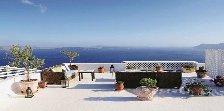 Terraza frente al mar con plantas y muebles